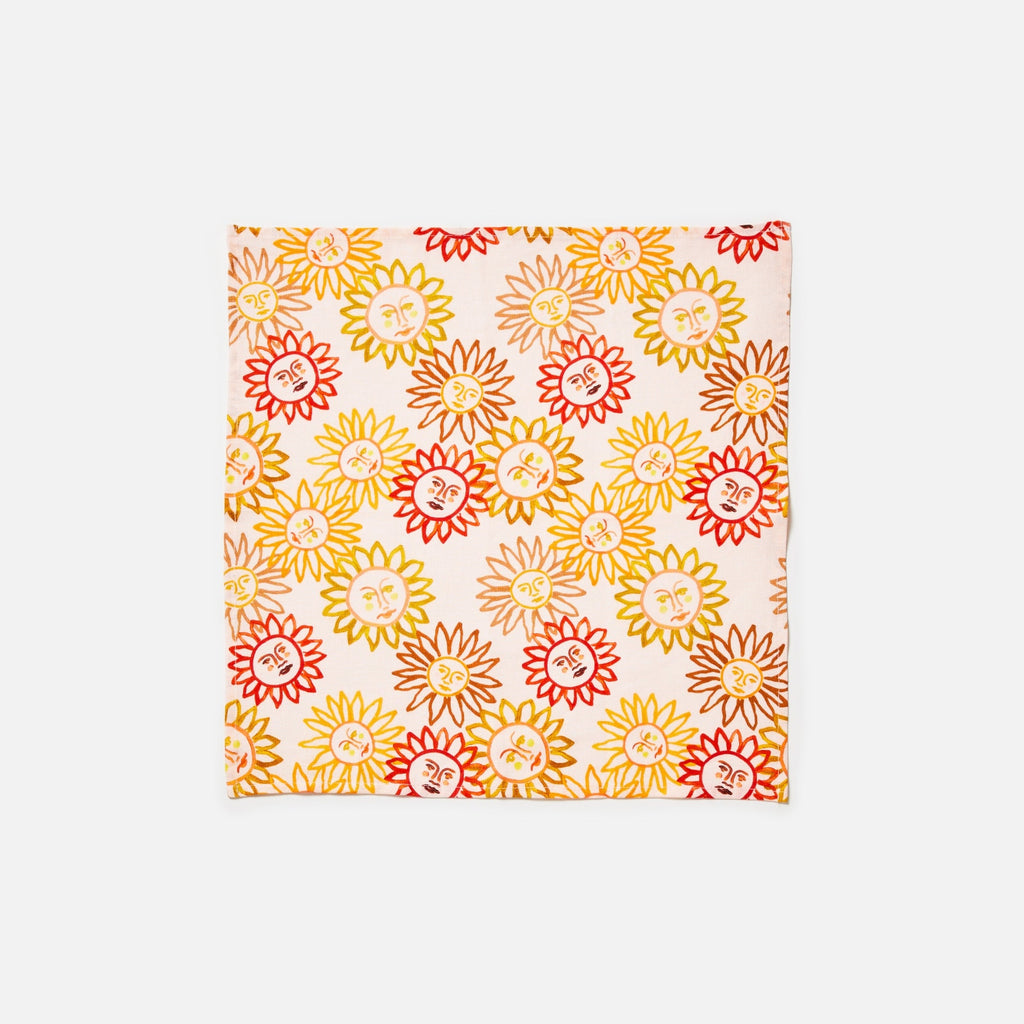 Hand painted sun motifs in pinks, oranges and reds on a dusty pink background