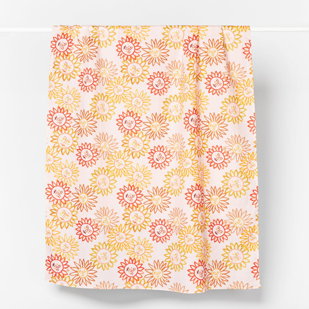 Hand painted sun motifs in varying shades of bright yellow, orange and bright red. Set on a dusty pink background.
